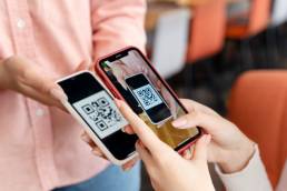 due ragazze mentre si scambiano il qr code tramite mobile