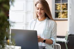 una ragazza al bar mentre scrive al computer