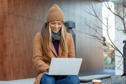 ragazza seduta in un parco con computer