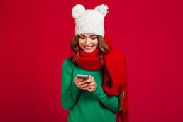 ragazza con sciarpa rossa e cappello bianco con il suo iPhone