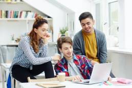 gruppo di amici mentre guardano insieme qualcosa al computer