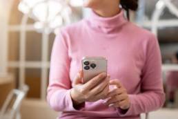 ragazza con in mano un iPhone seduta in un ristorante