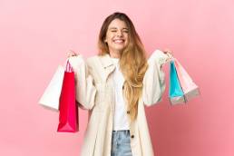 una ragazza con in mano tante buste dello shopping