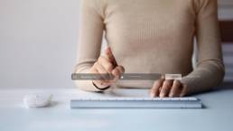 Mano che scrive su una tastiera, dettaglio ravvicinato