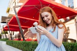 attractive-redhead-girl-playing-games-mobile-phone