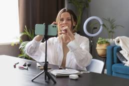 Donna che realizza un vlog di trucco con il suo smartphone