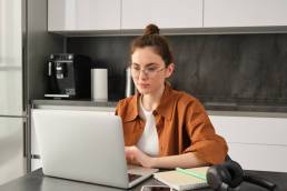 freelancer mentre lavora da casa nella sua cucina con il computer