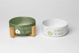 Due ciotole per animali, una verde e una bianca, entrambe con logo &ldquo;Il Rifugio di Anna&rdquo;.