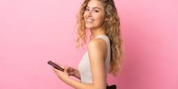 ragazza riccia bionda mentre manda un messaggio con il suo iPhone