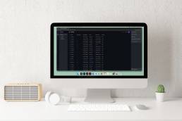 Schermo di un iMac con un pannello di amministrazione per la gestione di eventi, interfaccia scura con elenco di località, URL e posti disponibili