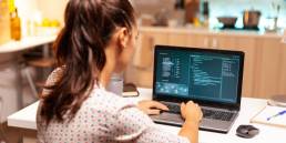 programmatrice intenta a scrivere codice sul suo laptop